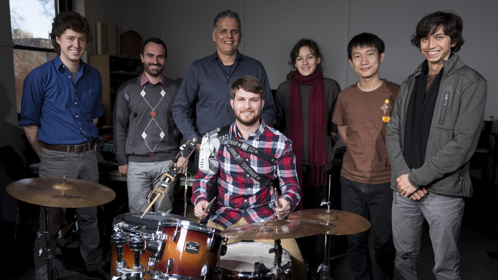 Gil Weinberg with Tyler White playing drums with a robotic arm